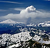 Forest fire smoke, looking somewhat like the mushroom cloud of an atomic bomb explosion, seen from Glacier Peak in July 1991. Mt. Baker is on the left and Mt. Shuksan is on the right. © Ed Cooper