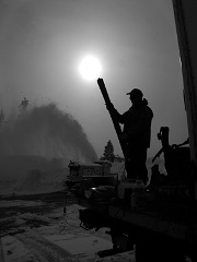 Preparing skis while a snow blower works in the background. Photo © John Stimberis.